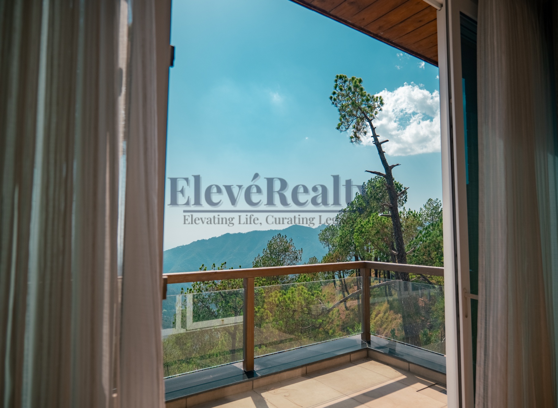 Balcony view framed through open doors and sheer curtains