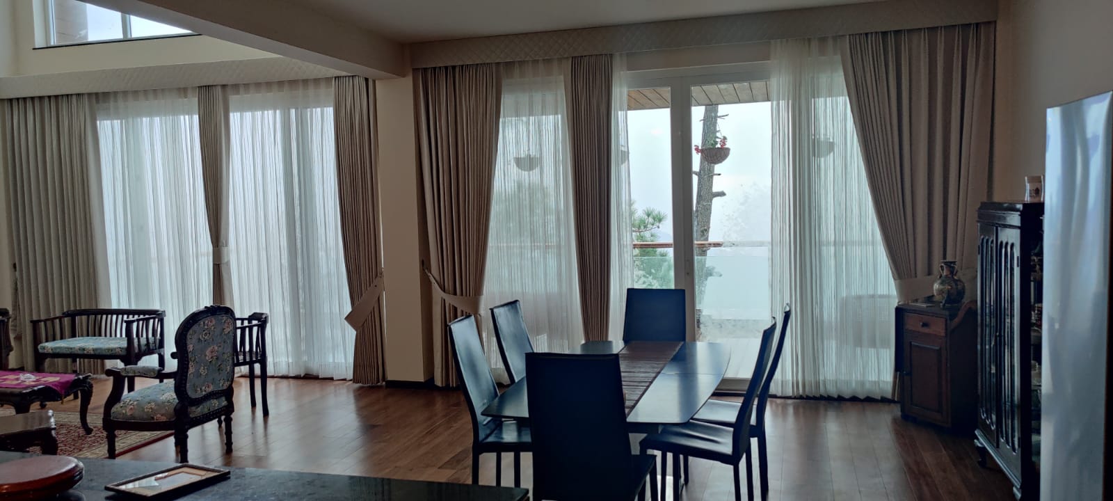 Open living and dining room with floor-to-ceiling windows facing the valley